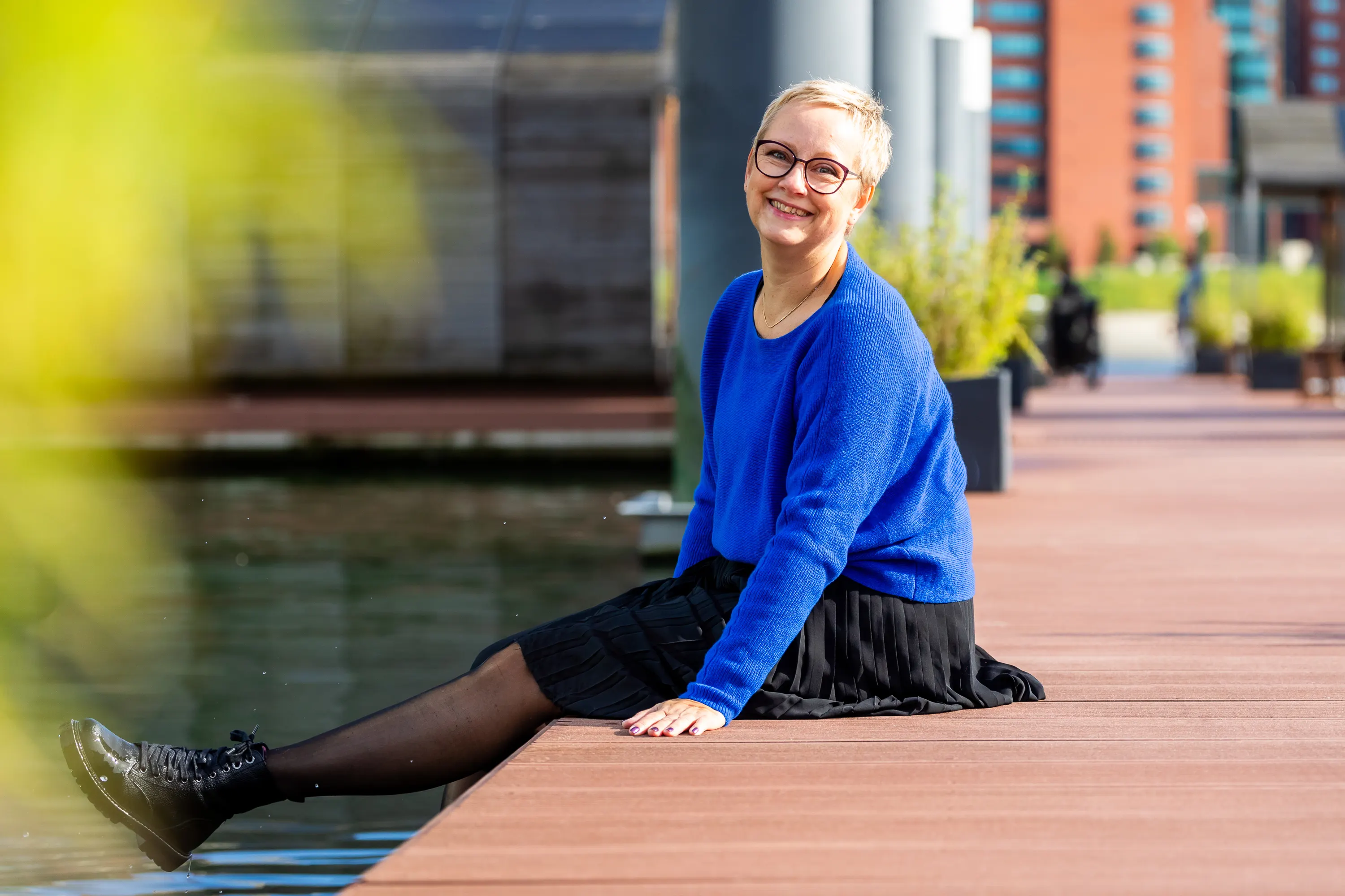 Joke van der Kraan, grafisch vormgever en eigenaar van VormBuilders, gefotografeerd in het stedelijke landschap van Rotterdam, waar haar professionele uitstraling en warme persoonlijkheid vastgelegd zijn tegen een achtergrond van dynamische architectuur.