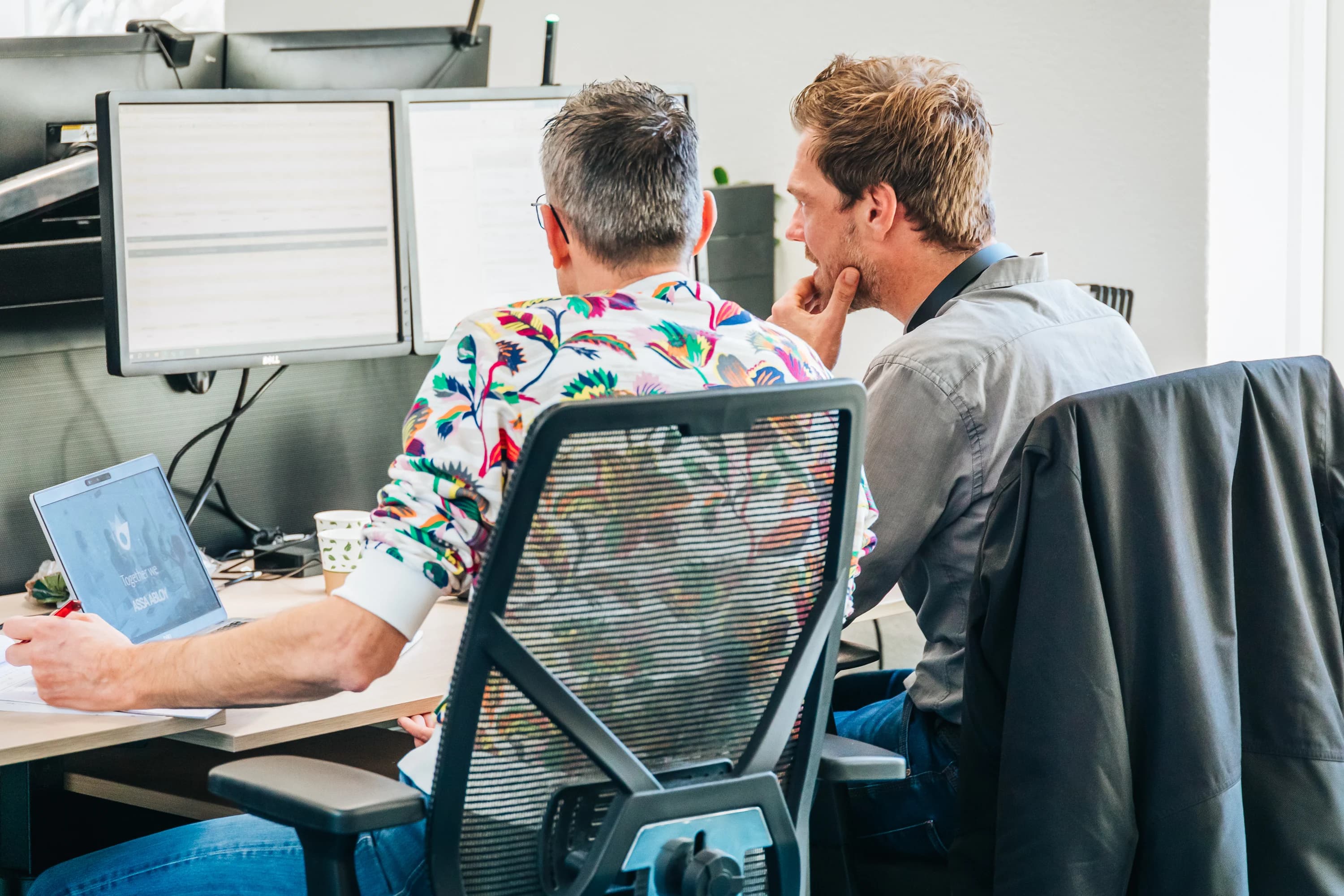 Twee collega’s werken samen achter een computer
