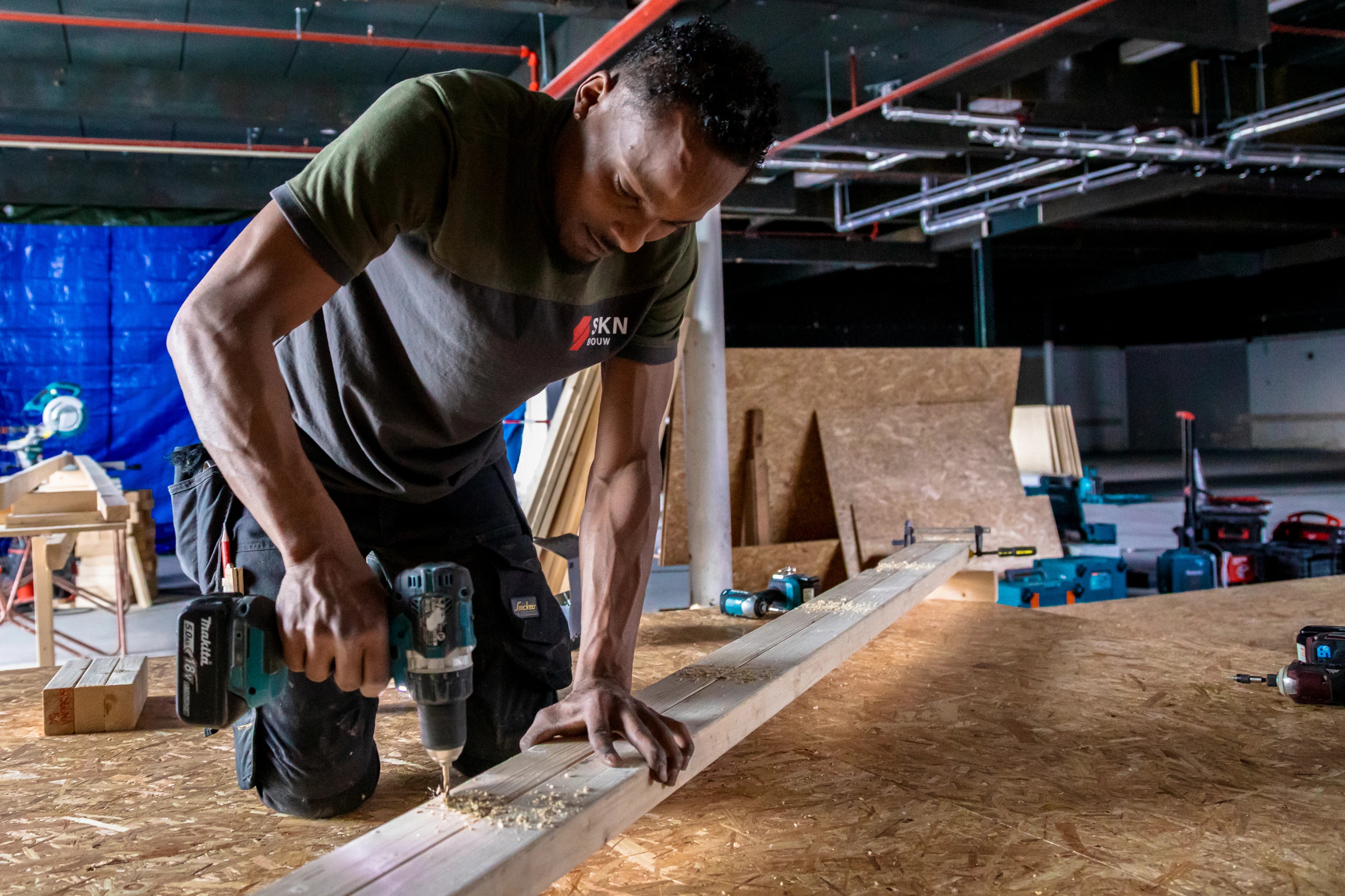 Medewerker werkt met hout tijdens een praktisch project