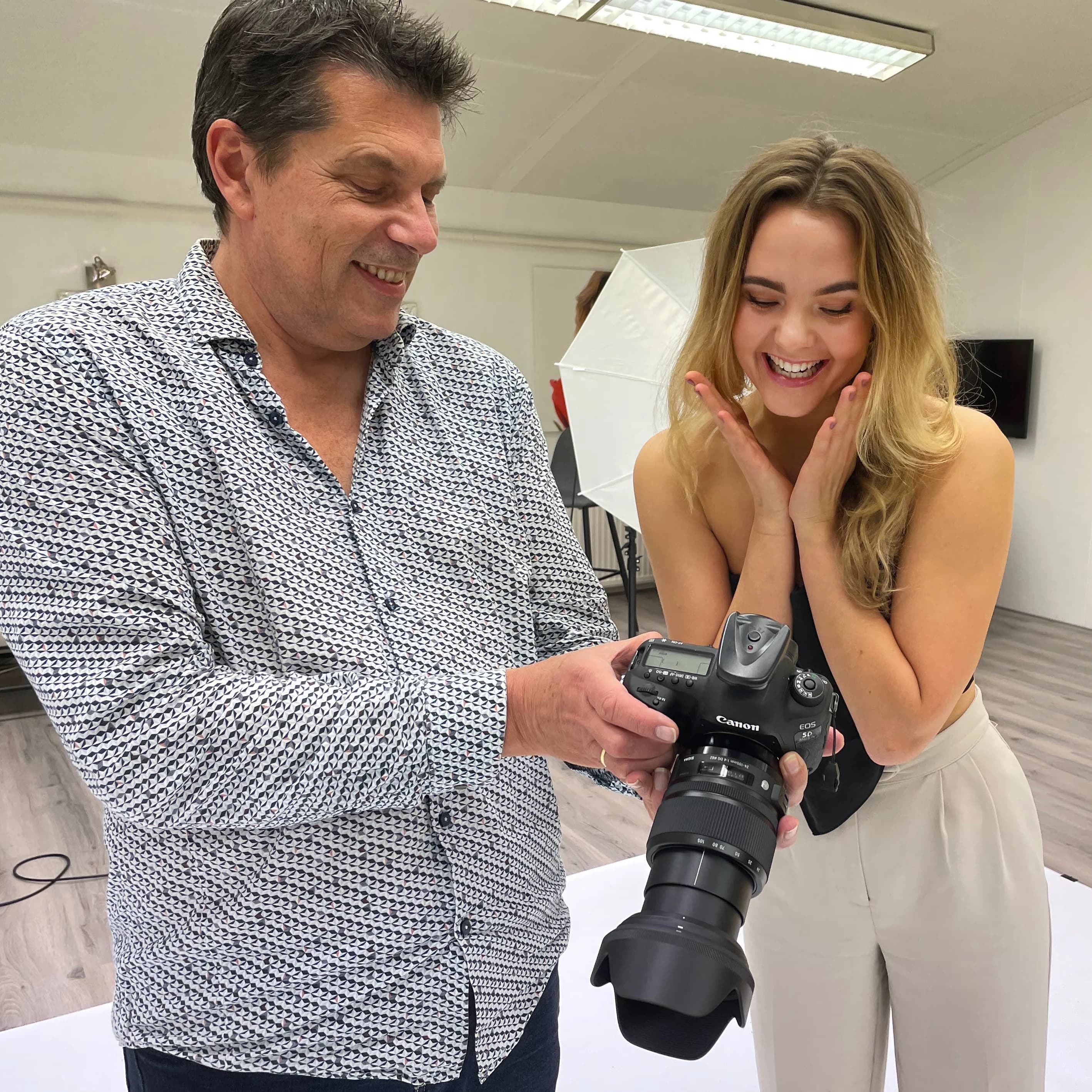 Francis bekijkt samen met een klant de foto’s tijdens een fotoshoot in de studio.